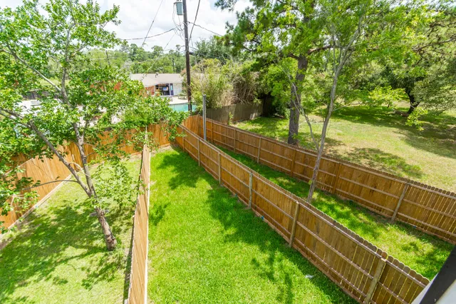a view of backyard with wooden fence