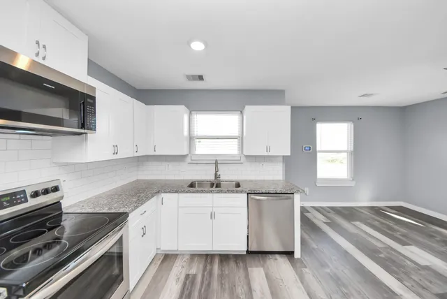 a kitchen with a sink stove top oven and cabinets