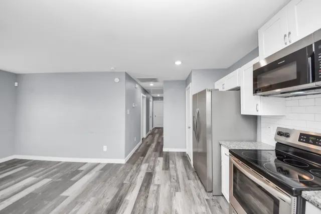 a view of a kitchen with a sink a stove microwave and cabinets