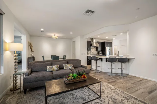 a living room with furniture and view of kitchen