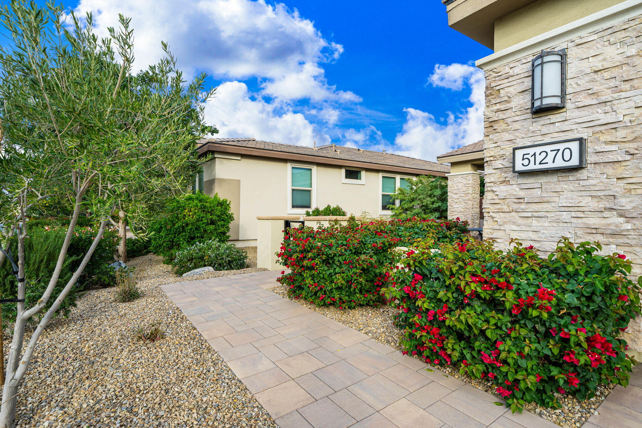 51270 North Two Palms Way Indio, CA 92201 - Photo 4 of 43 a bunch of flowers in front of yellow house