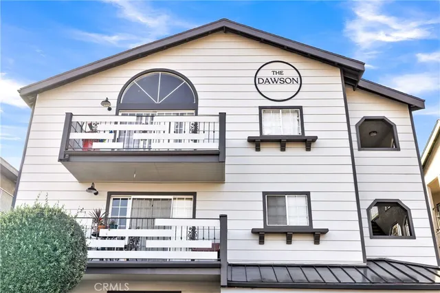 a view of a house with large windows and a table and chairs