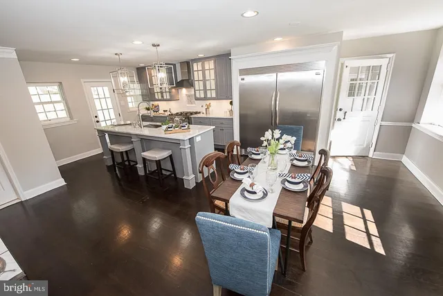a kitchen with a dining table chairs refrigerator and cabinets