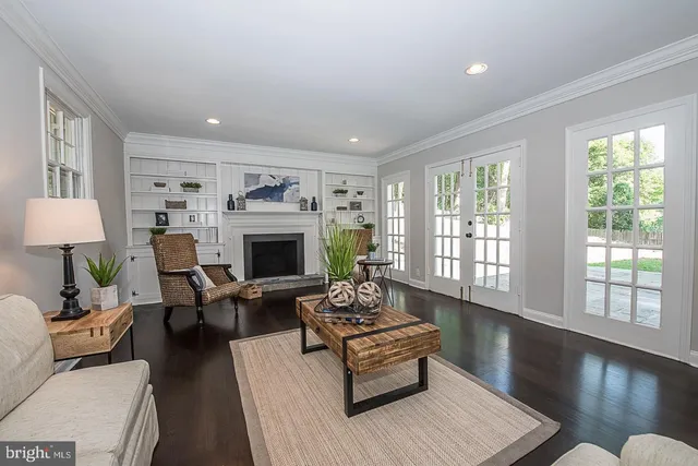 a living room with furniture fireplace and a large window
