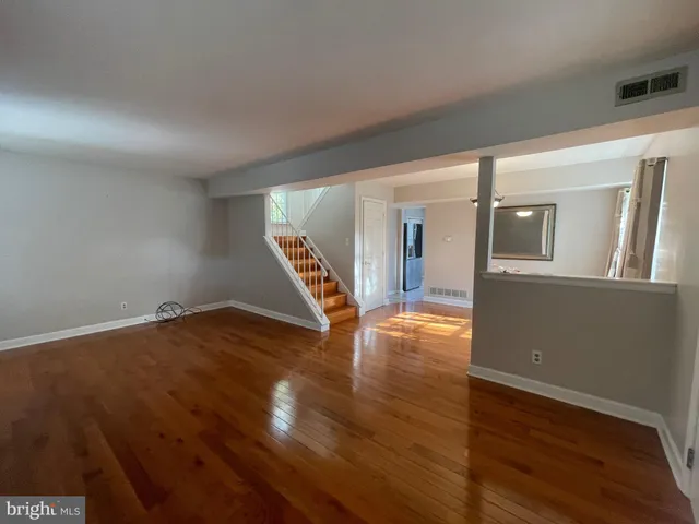 a view of empty room with wooden floor