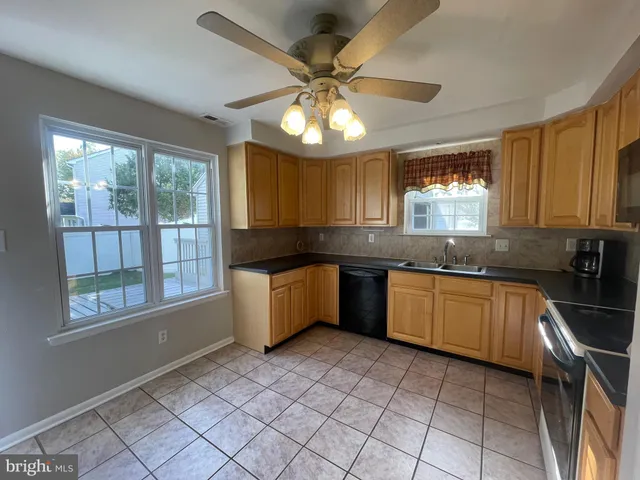 a kitchen with stainless steel appliances granite countertop a sink cabinets and window