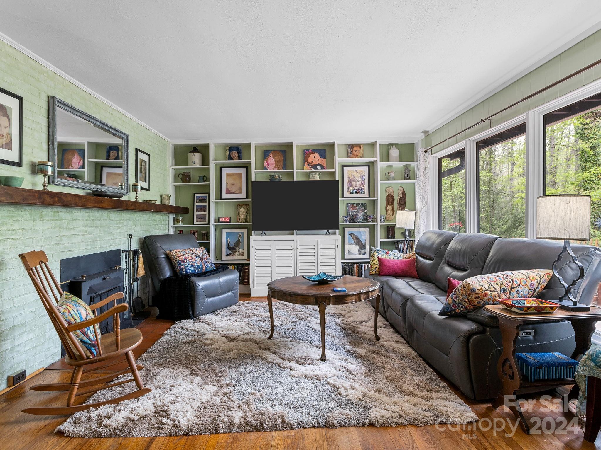 159 Jervey Road Tryon, NC 28782 - Photo 5 of 43 a living room with furniture a flat screen tv and a floor to ceiling window
