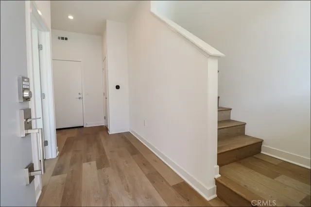 a view of a hallway with wooden floor and entryway
