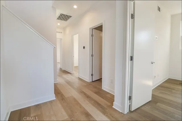 a view of a hallway with wooden floor and staircase