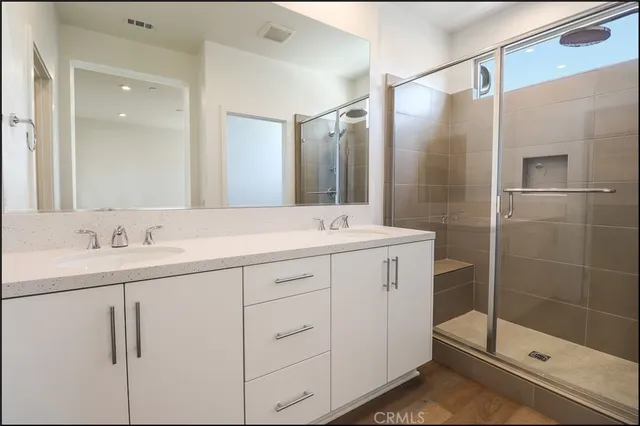a bathroom with a shower sink and mirror