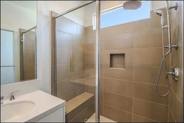 a bathroom with a sink shower and a mirror