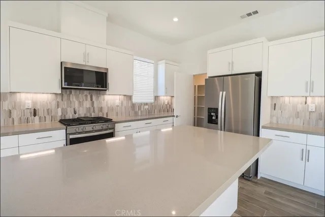 a kitchen with stainless steel appliances a refrigerator a stove a microwave and cabinets