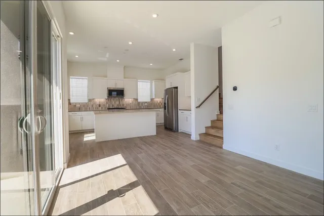 a view of a kitchen with wooden floor and electronic appliances