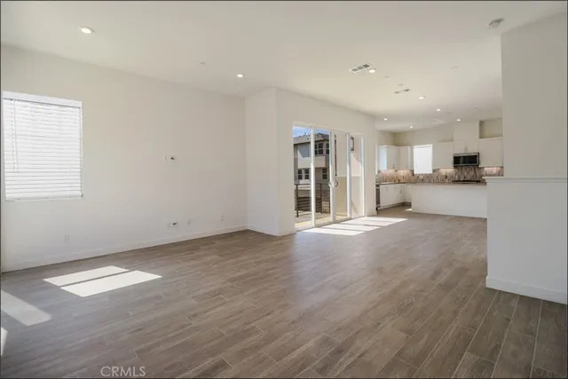 a view of empty room with wooden floor and window