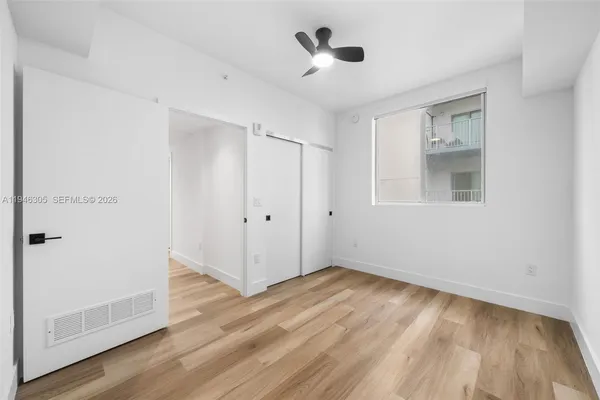 a view of an empty room with wooden floor