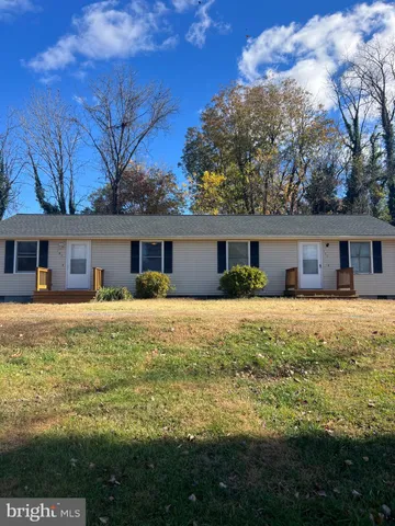a front view of house with a garden and deck