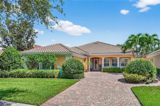 a front view of a house with a yard and potted plants