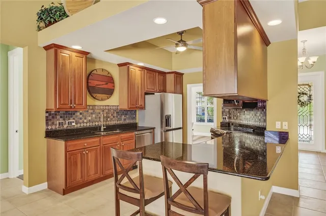 a kitchen with stainless steel appliances granite countertop a sink stove and refrigerator