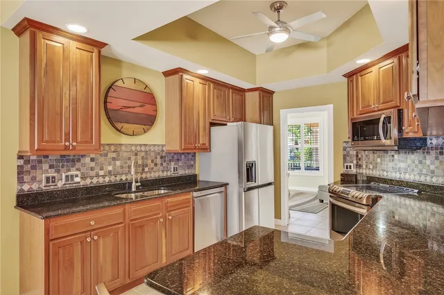 a kitchen with stainless steel appliances granite countertop wooden cabinets a stove top oven a sink and dishwasher