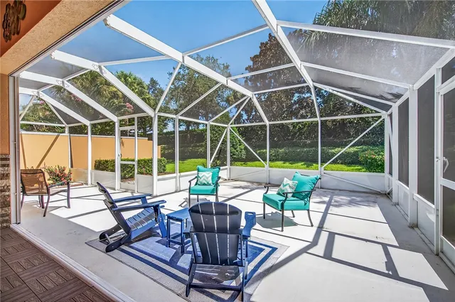 a view of a patio with table and chairs potted plants with floor to ceiling window