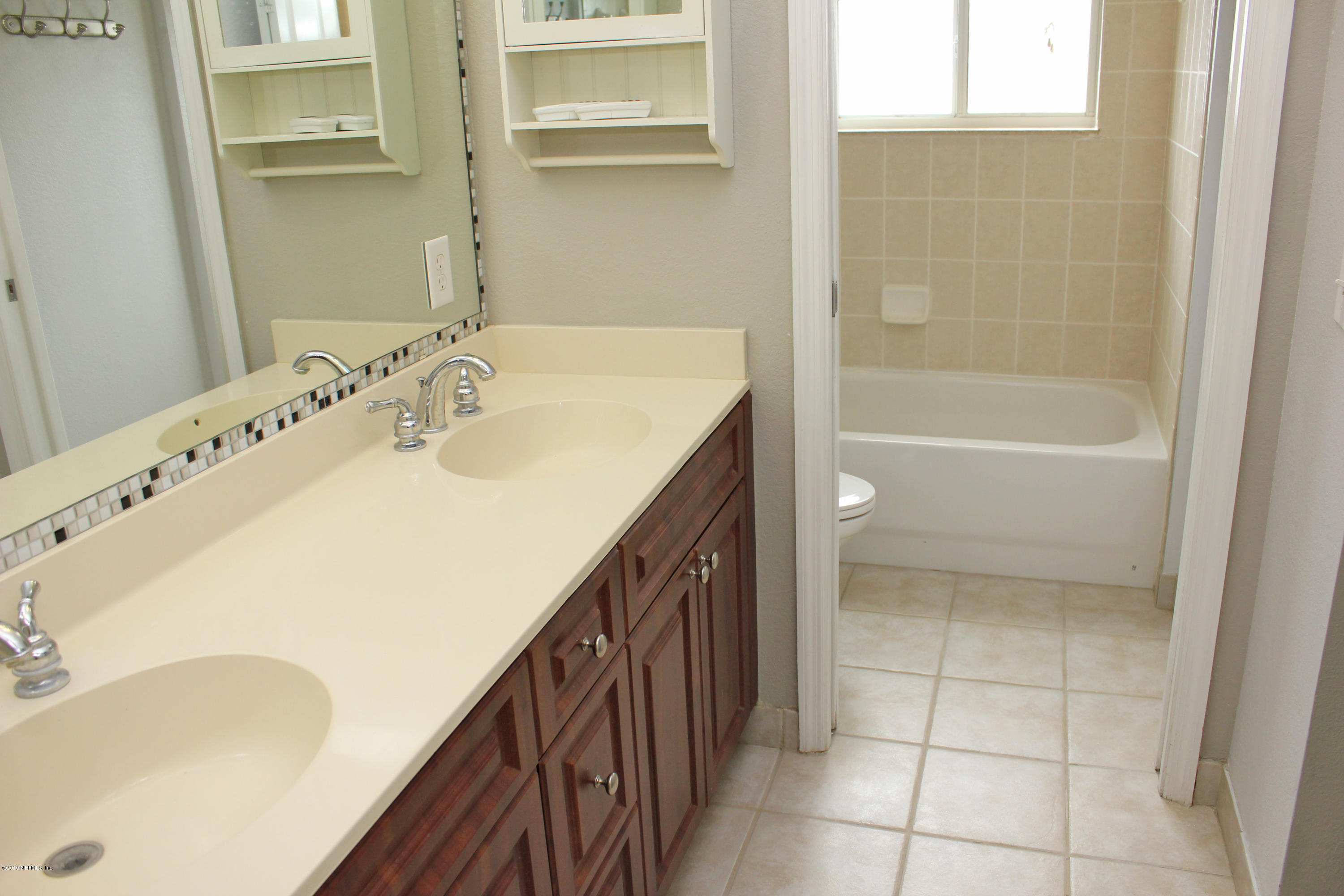 9745 Touchton Road, Unit 1323 Jacksonville, FL 32246 - Photo 12 of 19 a bathroom with a tub sink and mirror