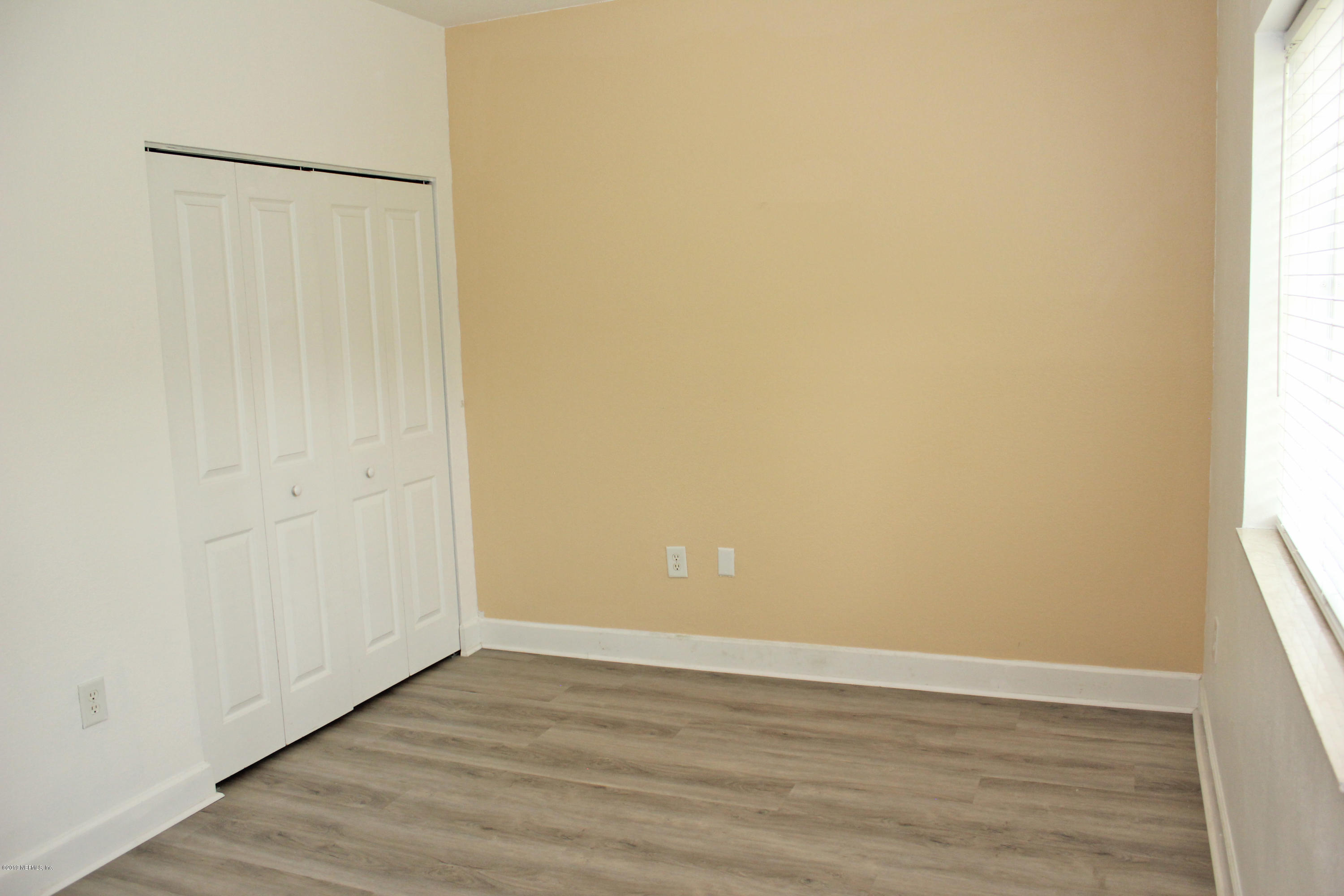 9745 Touchton Road, Unit 1323 Jacksonville, FL 32246 - Photo 14 of 19 a view of an empty room with wooden floor and a window