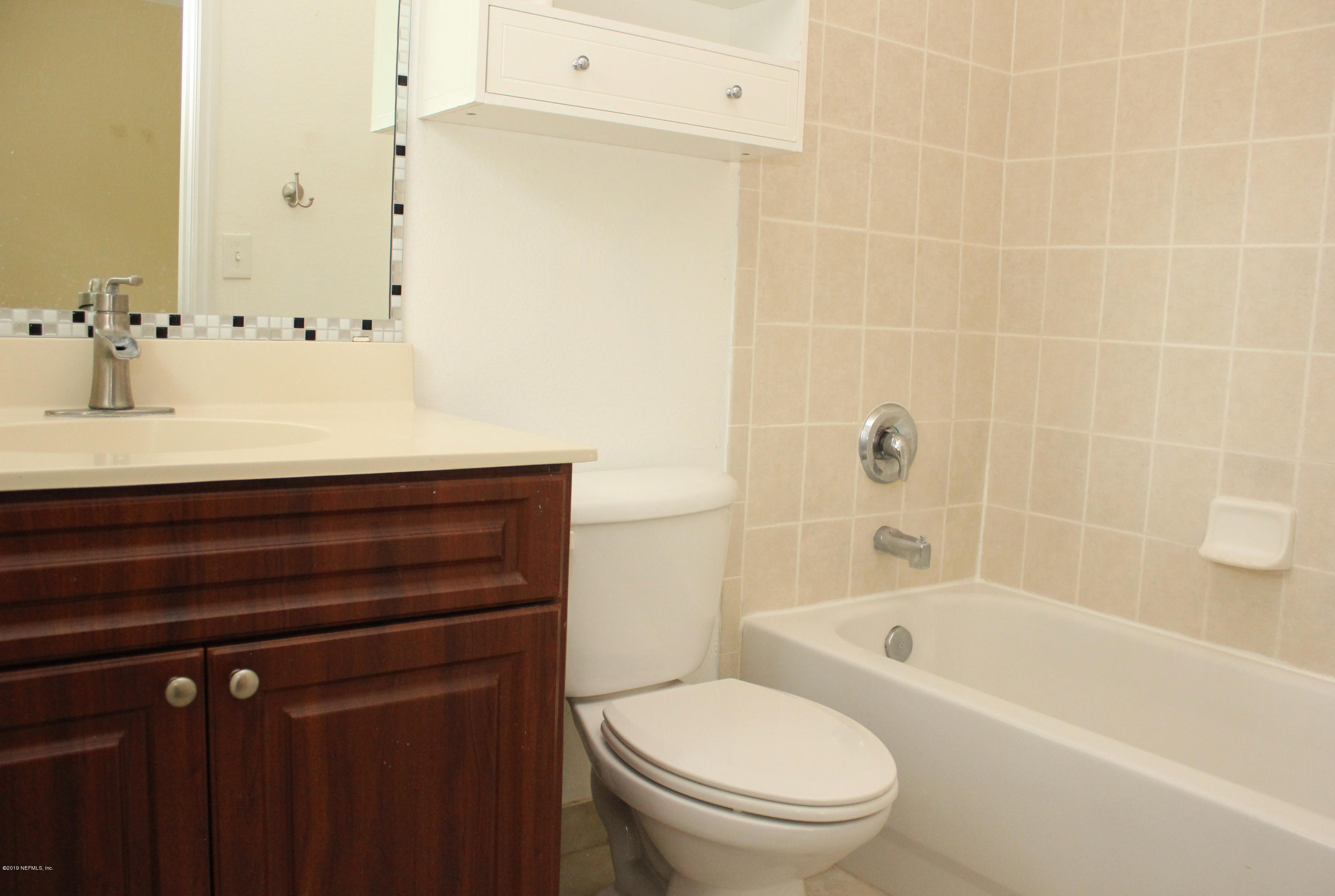 9745 Touchton Road, Unit 1323 Jacksonville, FL 32246 - Photo 16 of 19 a bathroom with a bathtub sink vanity mirror and toilet