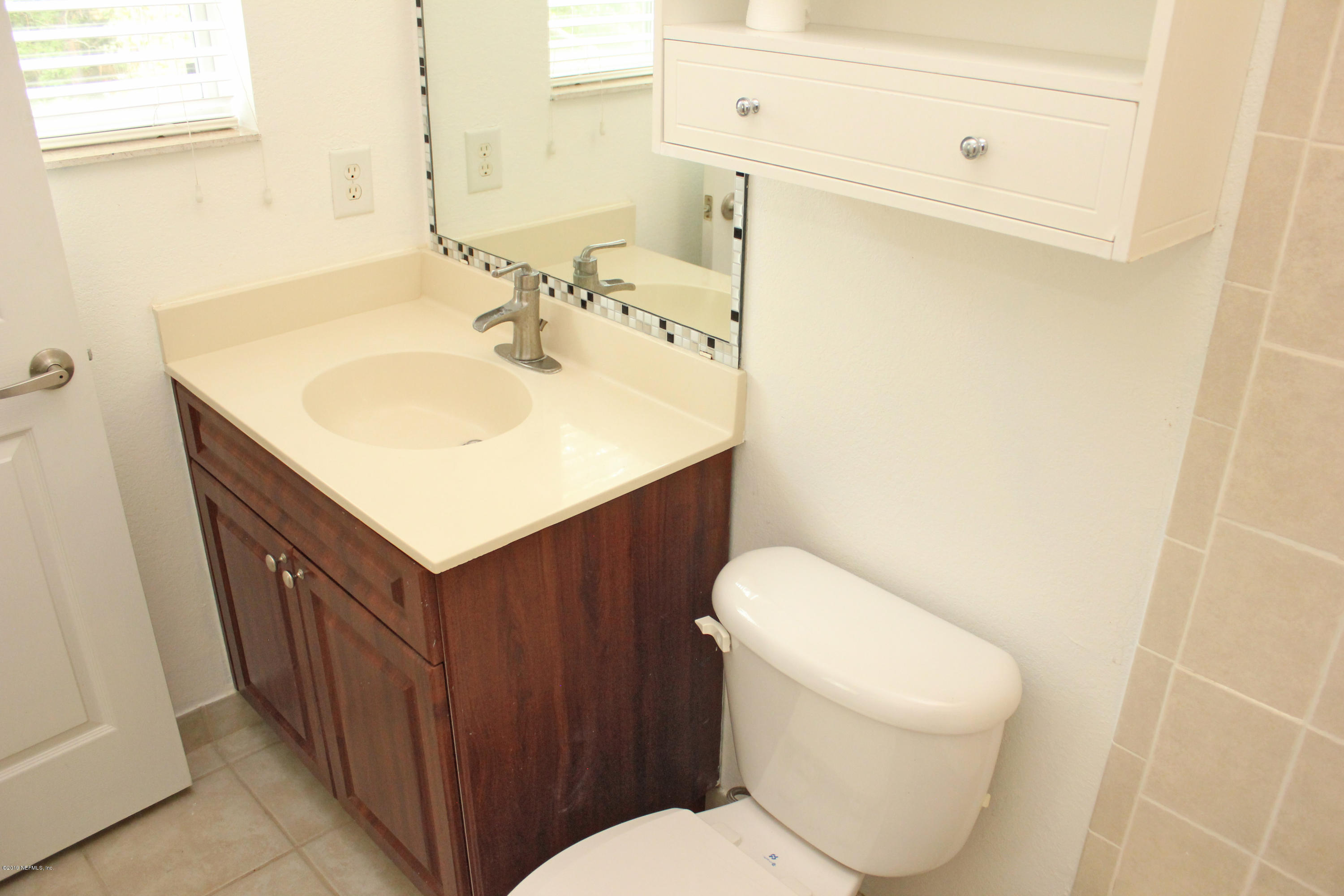9745 Touchton Road, Unit 1323 Jacksonville, FL 32246 - Photo 17 of 19 a bathroom with a sink a toilet and mirror