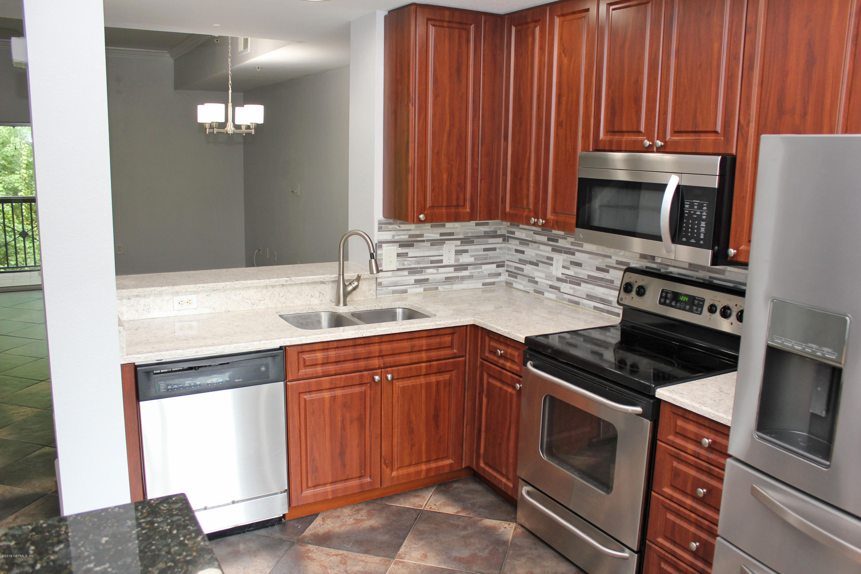9745 Touchton Road, Unit 1323 Jacksonville, FL 32246 - Photo 5 of 19 a kitchen with granite countertop wooden cabinets and stainless steel appliances