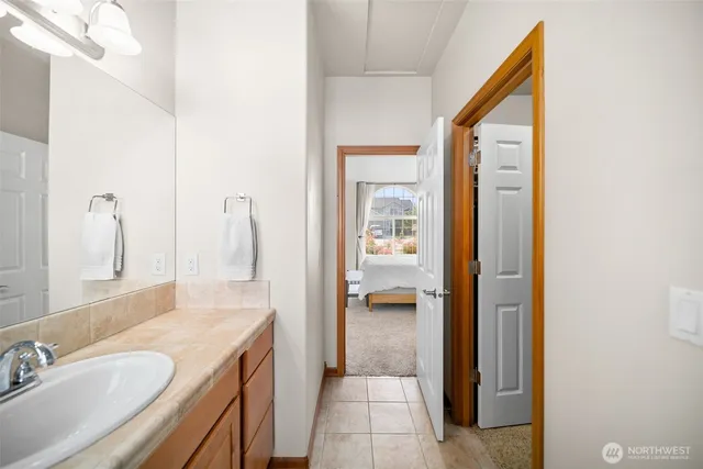 a en suite bathroom with a granite countertop sink and a mirror