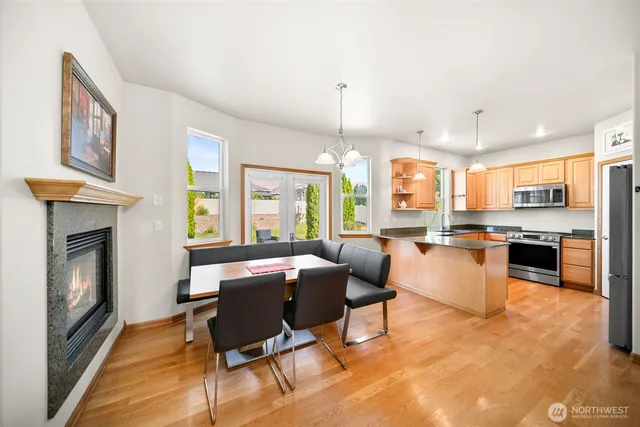 a living room with stainless steel appliances kitchen island granite countertop furniture and a fireplace