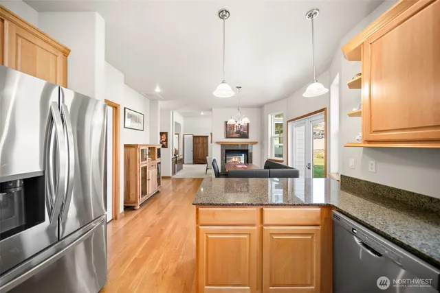 a kitchen with stainless steel appliances granite countertop a refrigerator a stove a sink and a refrigerator