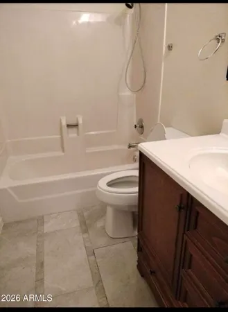 a bathroom with a granite countertop sink a toilet and shower
