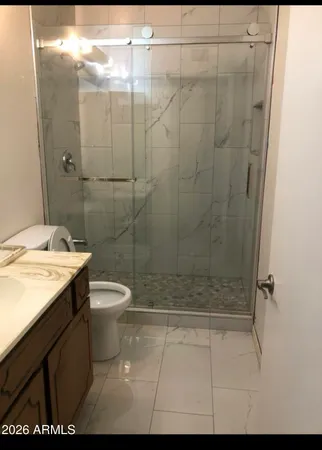 a bathroom with a sink a toilet and shower