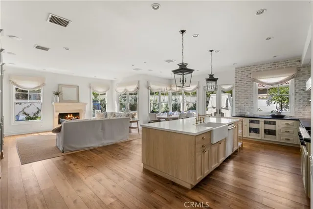 a large white kitchen with a stove top oven and sink