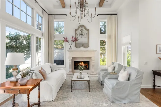 a living room with furniture a chandelier and a fireplace