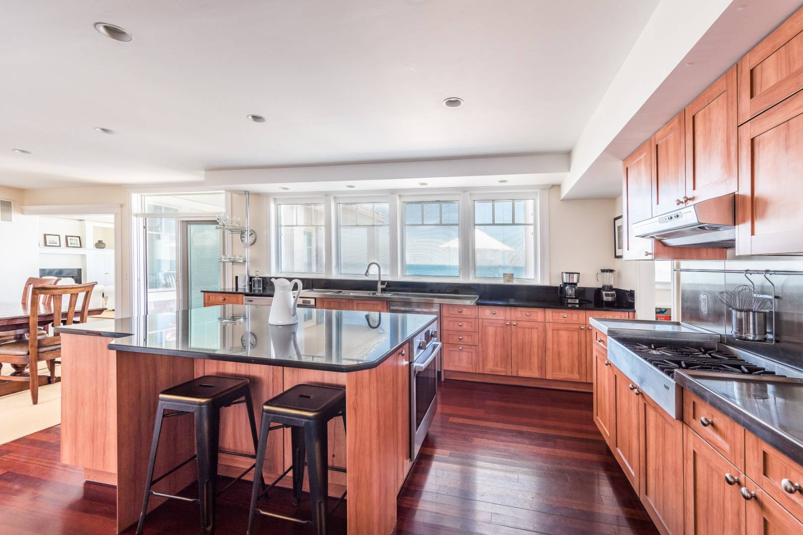 32 Captain Kidds Path Montauk, NY 11954 - Photo 8 of 25 a kitchen with stainless steel appliances granite countertop a stove a sink dishwasher a dining table and chairs with wooden floor