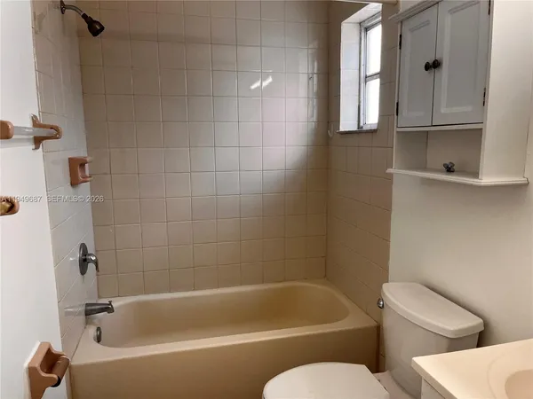 a white bath tub sitting next to a white toilet and sink