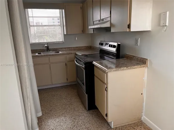a kitchen with a sink stove and cabinets