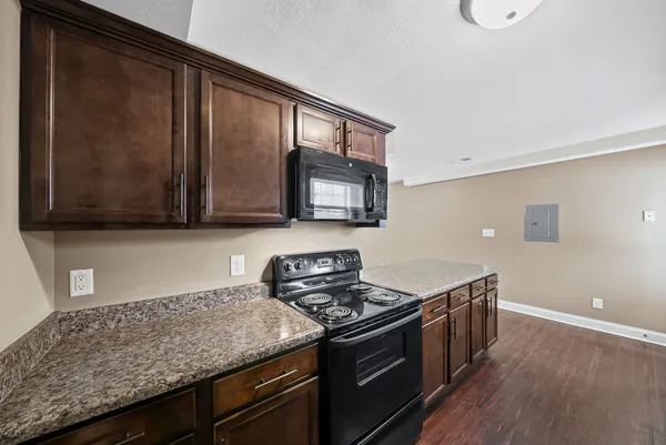 a kitchen with stainless steel appliances granite countertop a stove a sink and a microwave