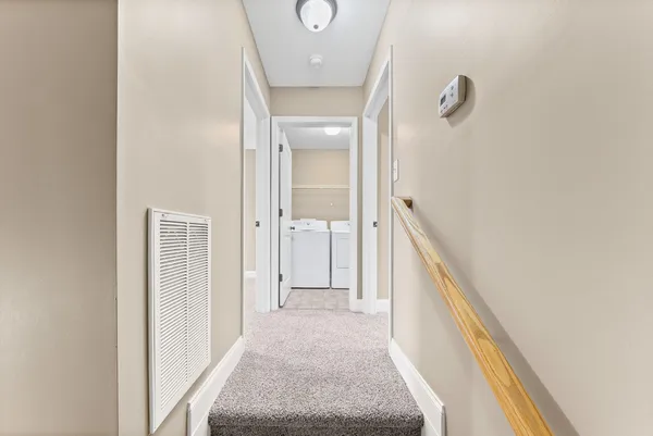 a view of a hallway with wooden floor and staircase