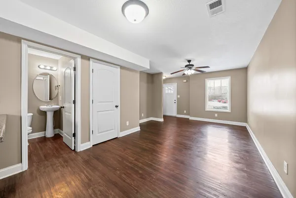 an empty room with wooden floor and windows