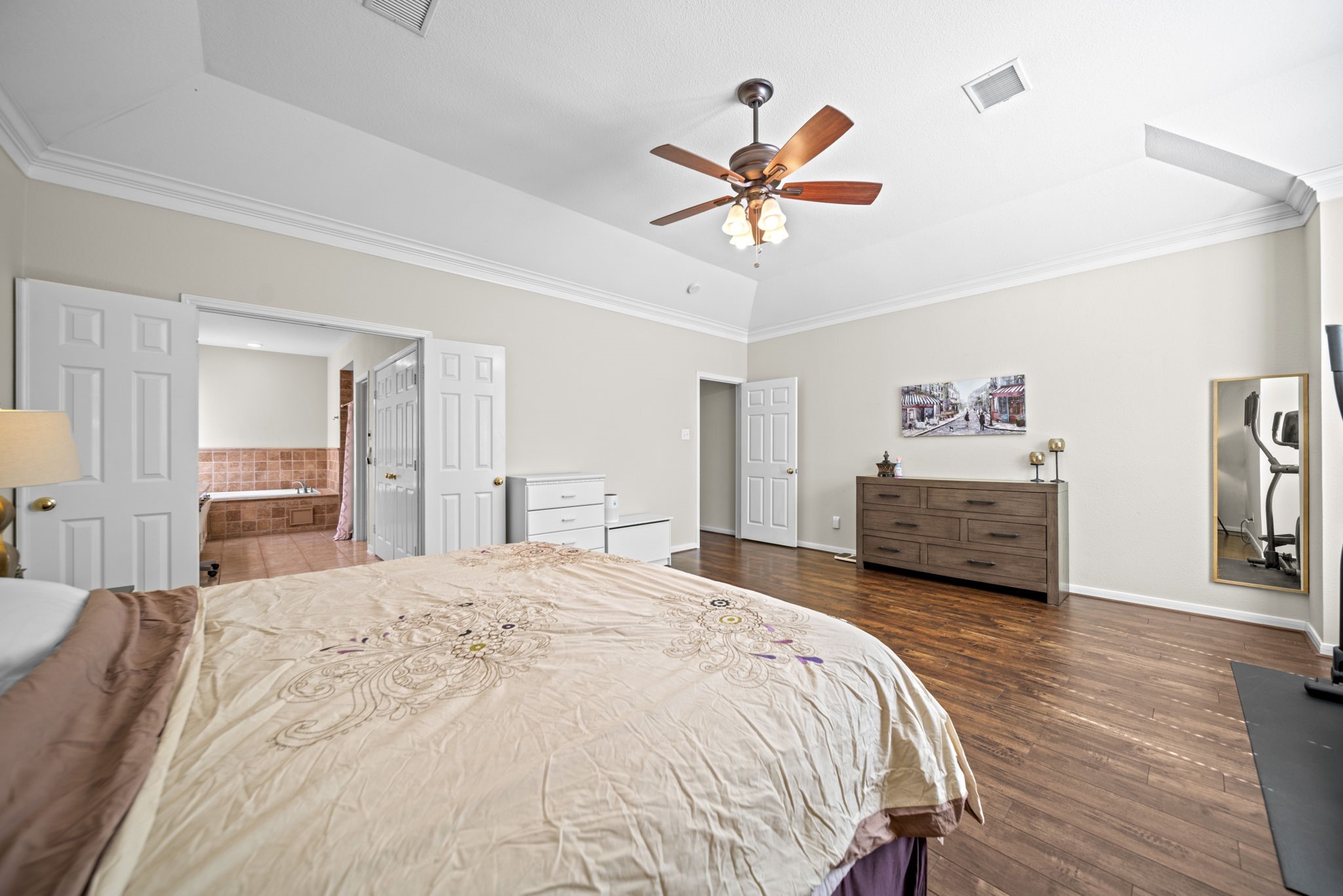20727 Shadow Mill Court Katy, TX 77450 - Photo 23 of 48 a spacious bedroom with a bed a dresser and a chandelier