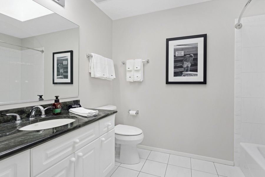 1720 Maple Avenue, Unit 405 Evanston, IL 60201 - Photo 12 of 17 a bathroom with a toilet a sink and mirror