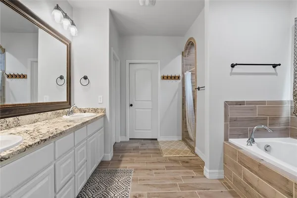 a spacious bathroom with a granite countertop tub sink and mirror