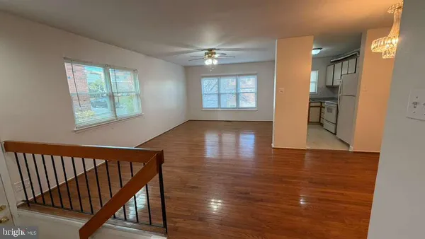 a view of a hallway with wooden floor and staircase