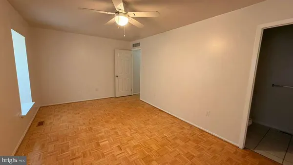 an empty room with a ceiling fan and a window