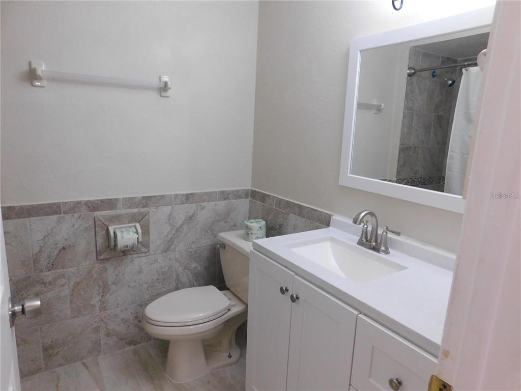 21150 Gertrude Avenue, Unit B4 Port Charlotte, FL 33952 - Photo 8 of 10 a bathroom with a toilet sink and mirror