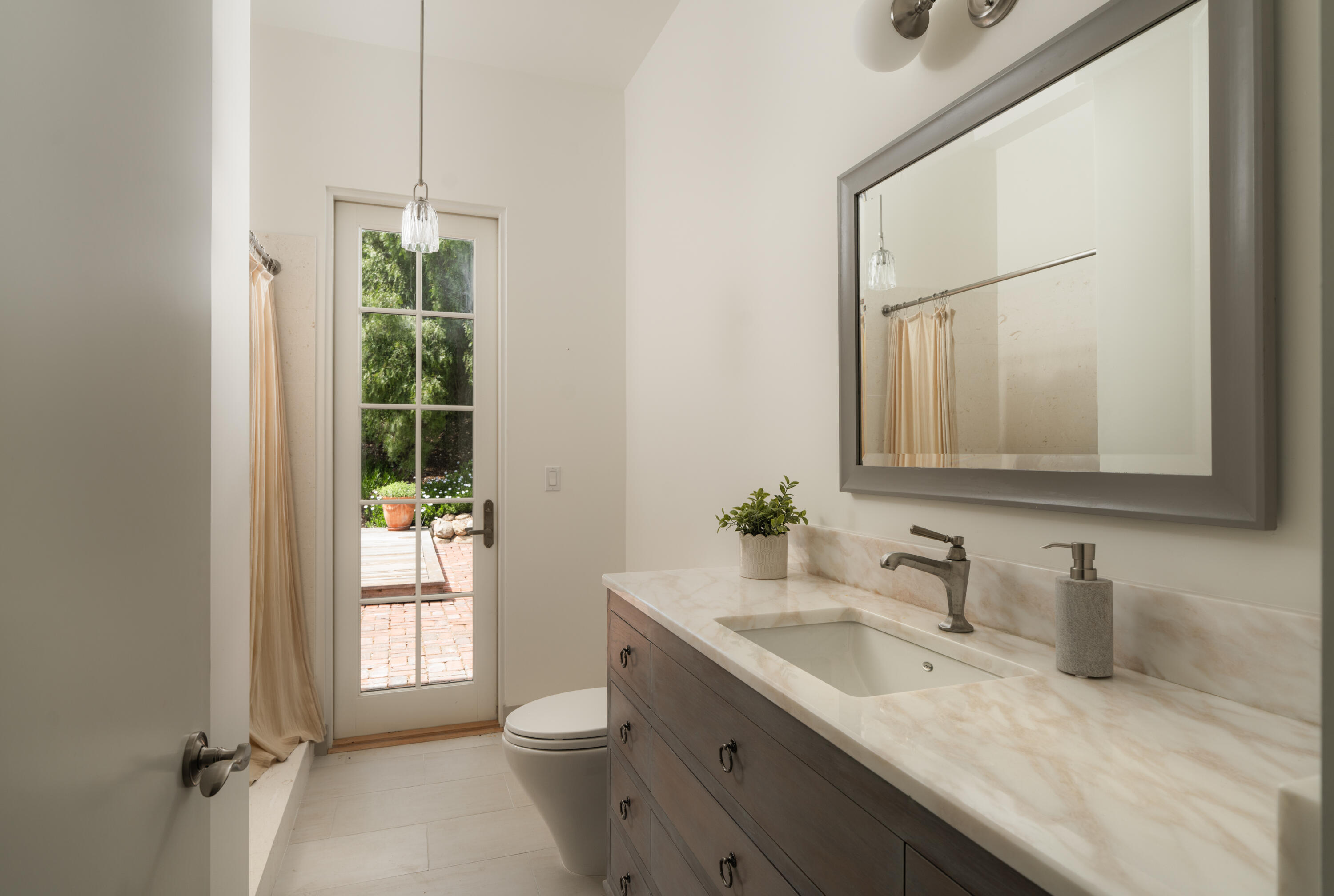 626 Sea Ranch Drive Santa Barbara, CA 93109 - Photo 29 of 38 a bathroom with a granite countertop sink a toilet and a mirror