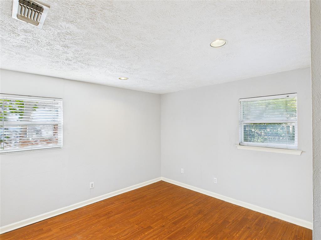 6909 Valhalla Road Fort Worth, TX 76116 - Photo 6 of 15 a view of an empty room with wooden floor and a window